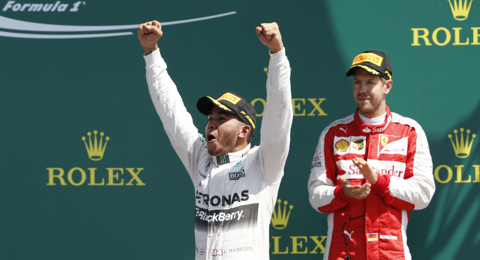 Formula One - F1 - British Grand Prix 2015 - Silverstone, England - 5/7/15 Mercedes' Lewis Hamilton celebrates his win on the podium with Ferrari's Sebastian Vettel (R) Reuters / Phil Noble