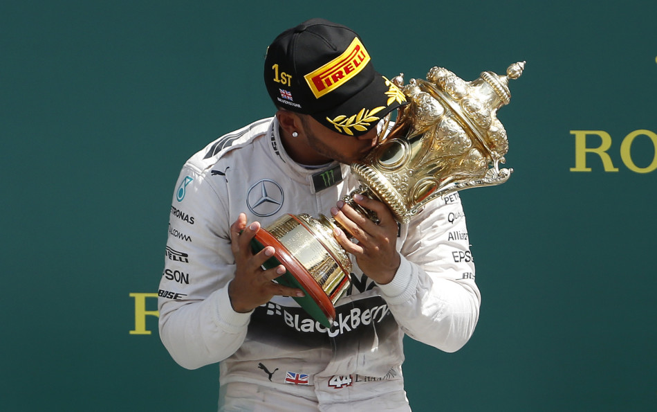 Formula One - F1 - British Grand Prix 2015 - Silverstone, England - 5/7/15 Mercedes' Lewis Hamilton celebrates his win on the podium with the trophy Reuters / Phil Noble