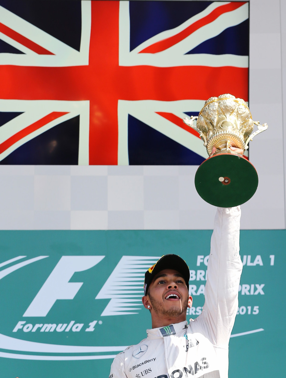 Formula One - F1 - British Grand Prix 2015 - Silverstone, England - 5/7/15 Mercedes' Lewis Hamilton celebrates his win on the podium with the trophy Reuters / Paul Childs