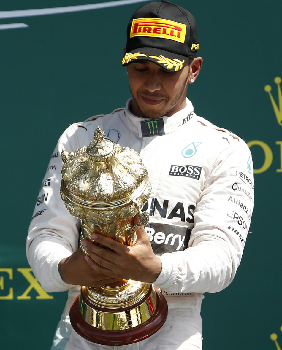 Formula One - F1 - British Grand Prix 2015 - Silverstone, England - 5/7/15 Mercedes' Lewis Hamilton celebrates his win on the podium with the trophy Reuters / Phil Noble